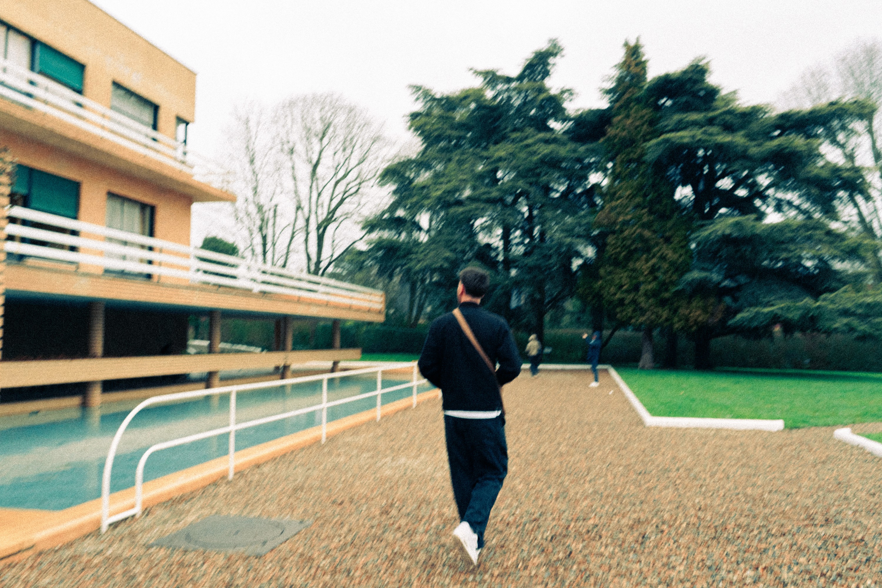 A close-up of a person wearing green-tinted glasses, with a serious expression and smooth skin.