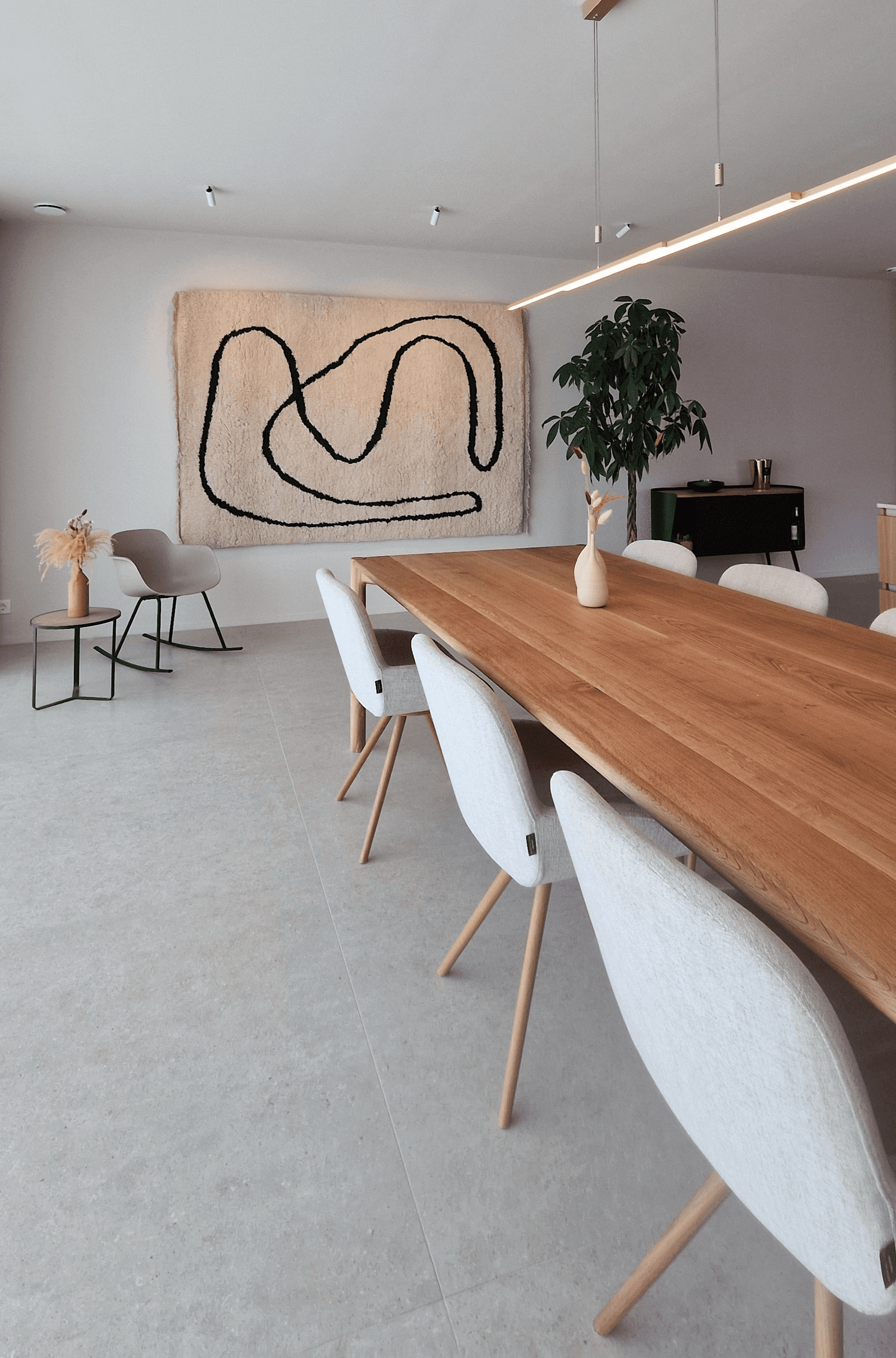 Minimal dining area with custom oak table and contemporary artwork