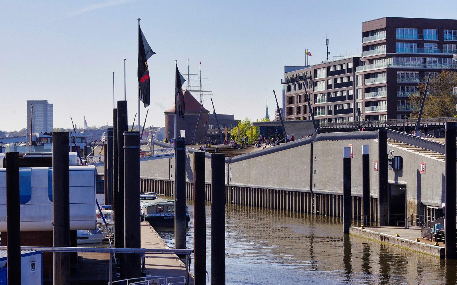 Harbor view in Hamburg with modern buildings and docked boats.