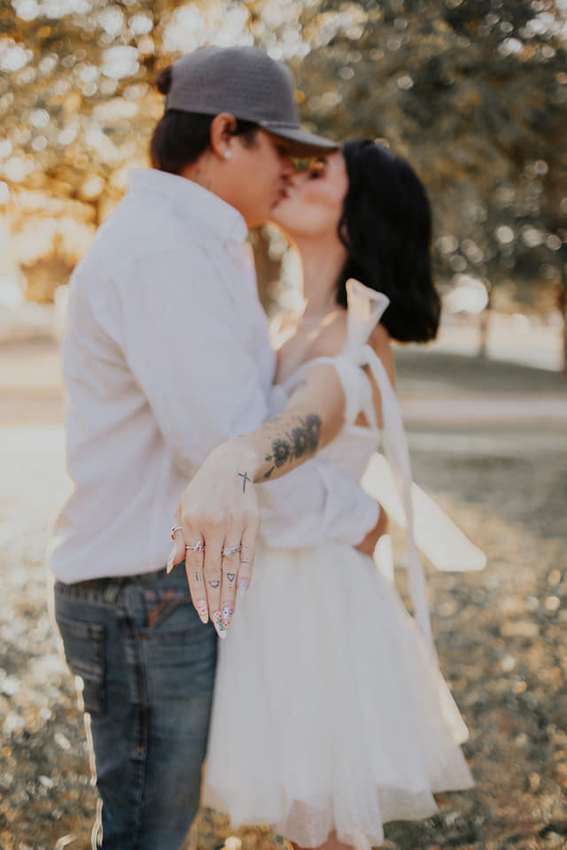 A couple stands closely in an intimate embrace.