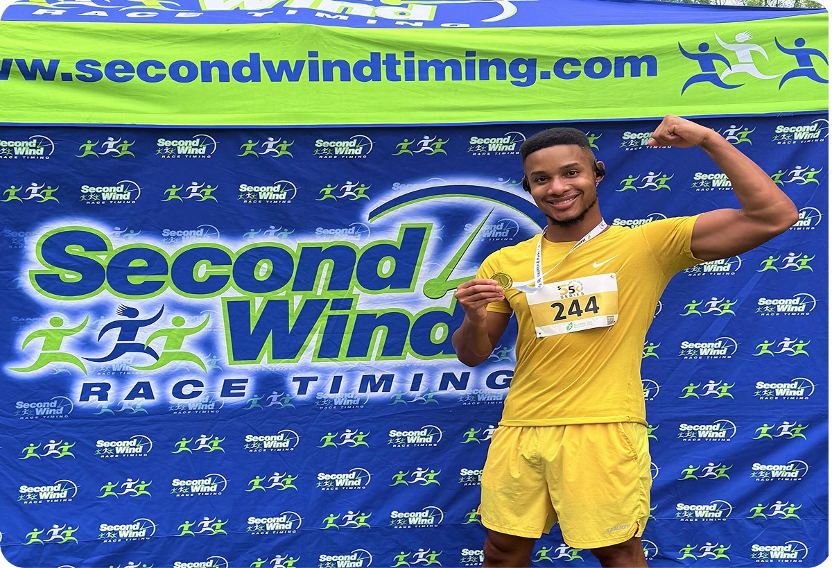 Ke’Ron Hall posing after a race in a yellow running uniform at a competitive track event.