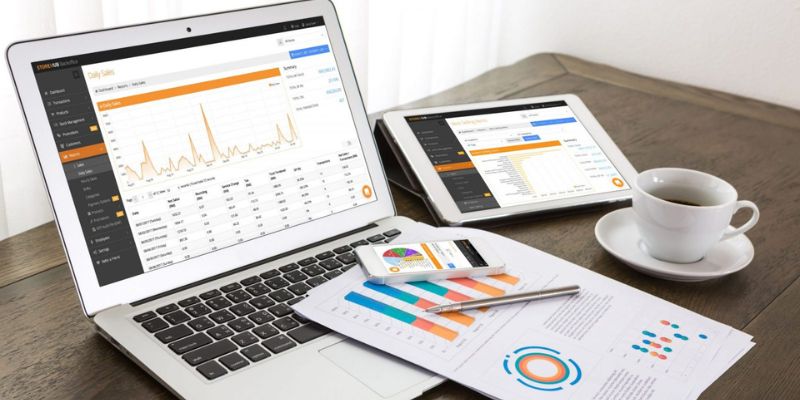 A laptop and an iPad showing the sales report from a retail business.