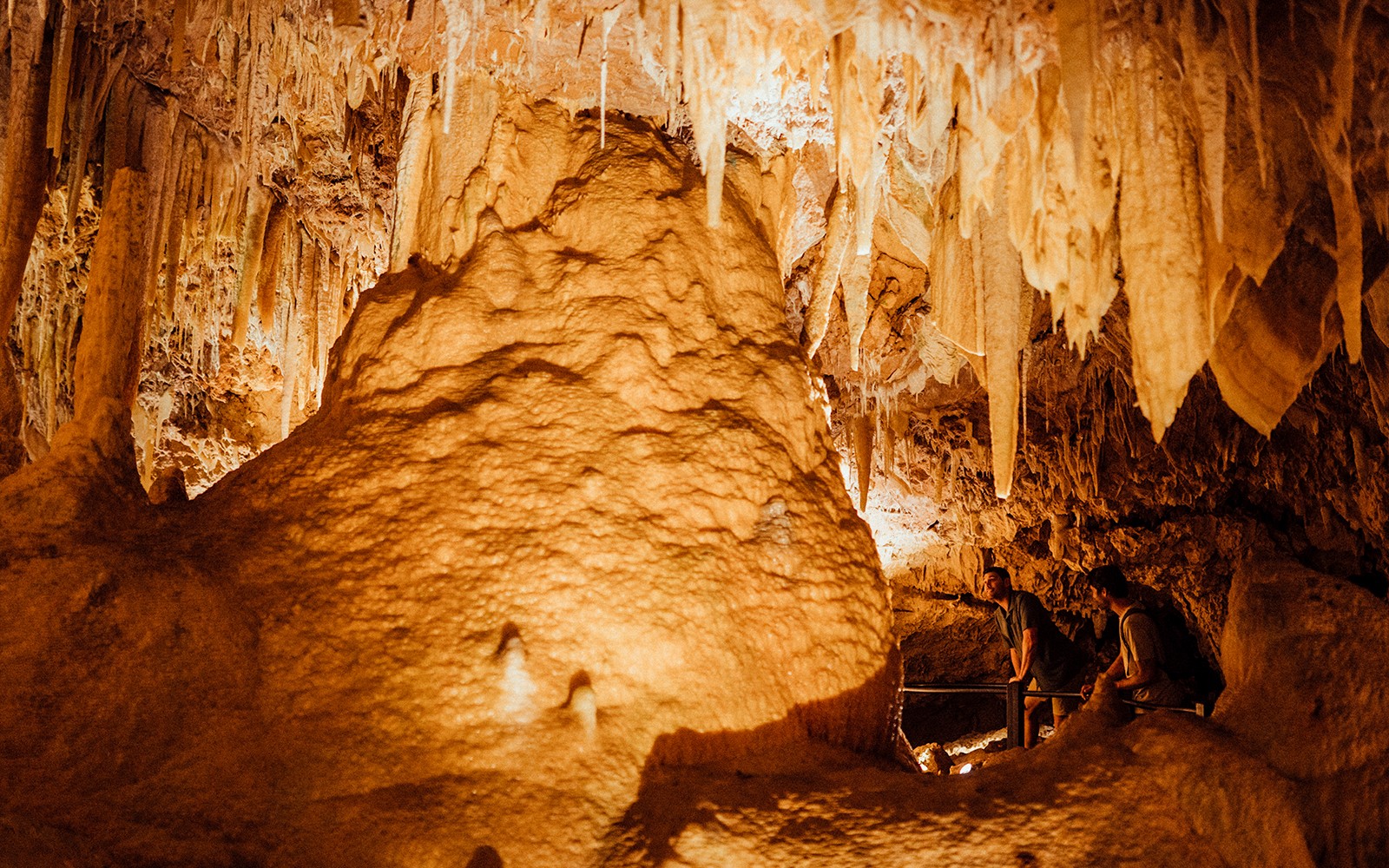 Ngilgi Cave stalactites and rock formations with visitors exploring the Ancient Lands Experience.