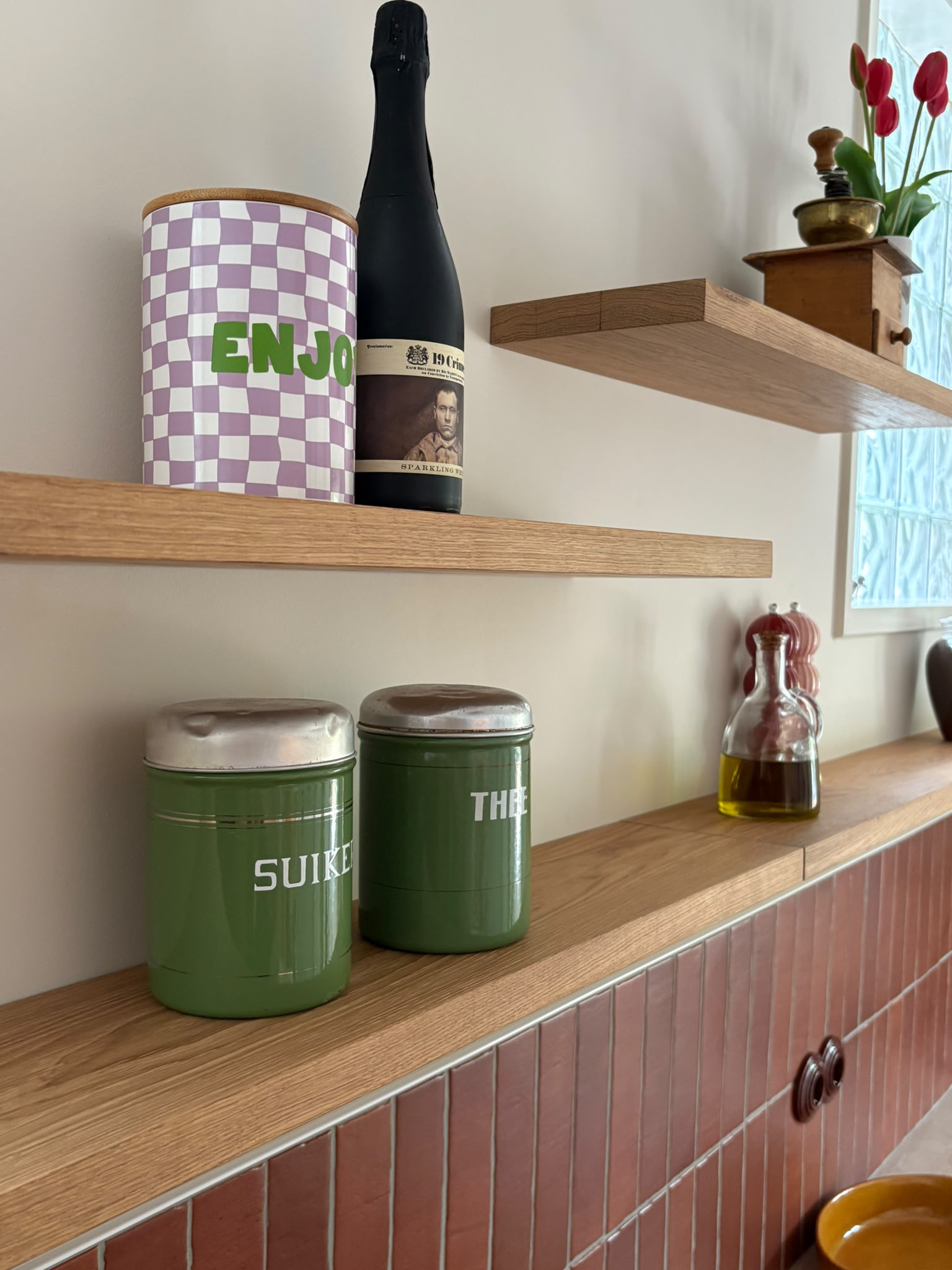 Keukenplanken van gerecupereerd eikenhout die onzichtbaar zijn opgehangen aan de muur met daarop keukenaccessoires