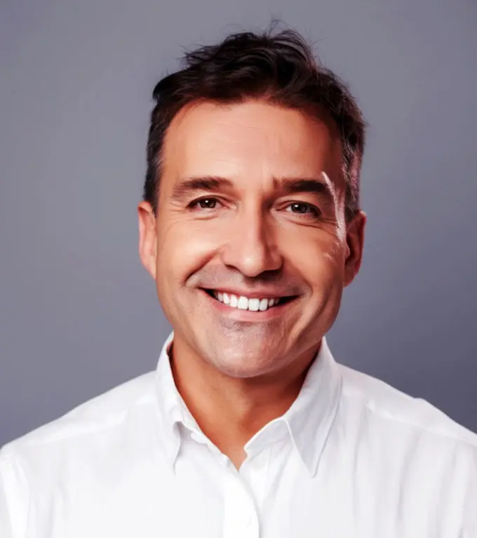 Portrait of a smiling man in a white collared shirt.