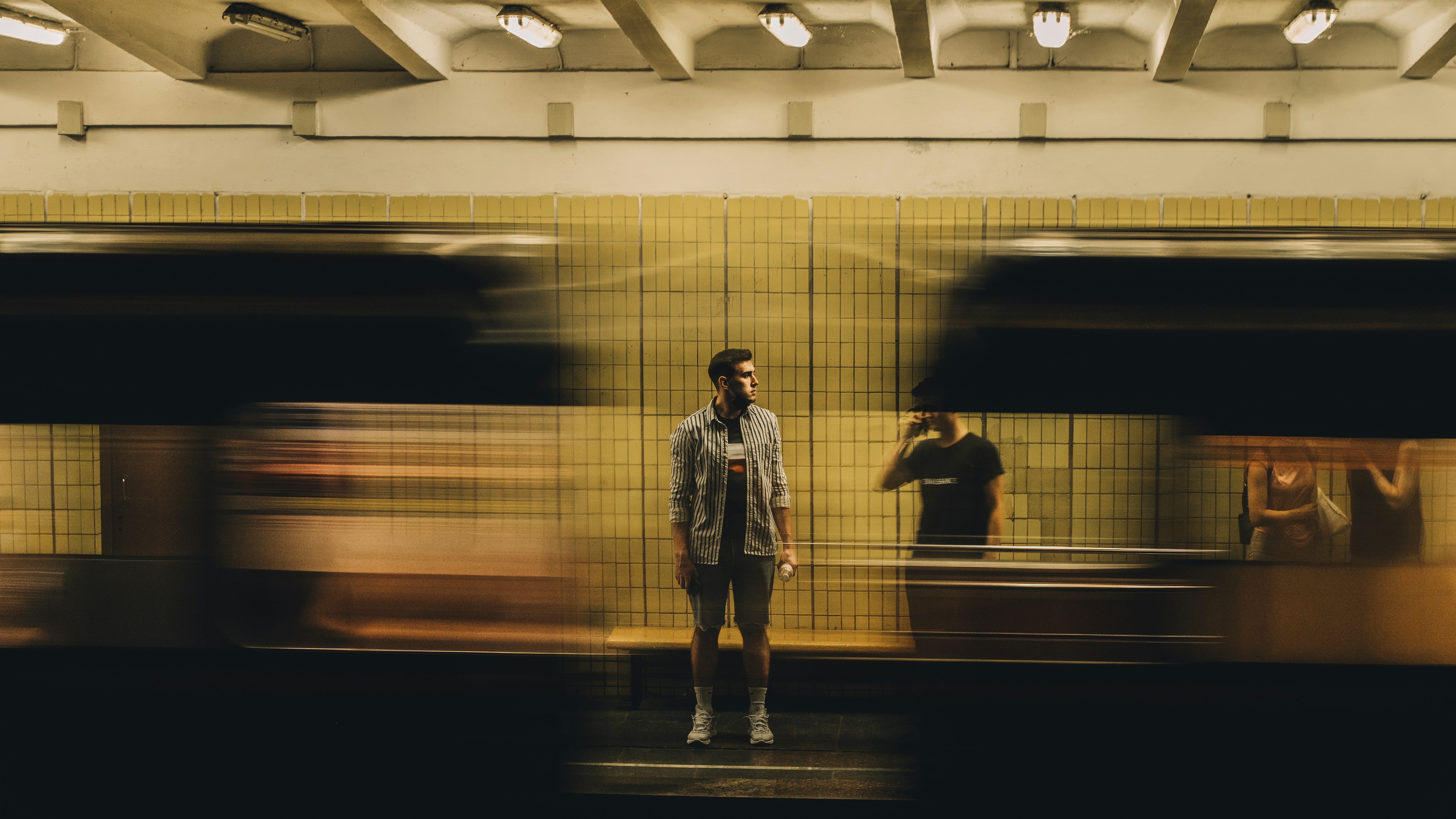 man in white jacket standing in front of train
