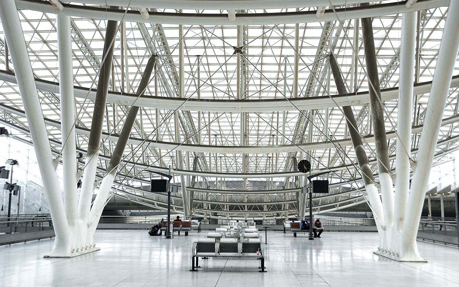 Interior spațios al terminalului de la Aeroportul Charles de Gaulle, Paris, cu o arhitectură modernă.