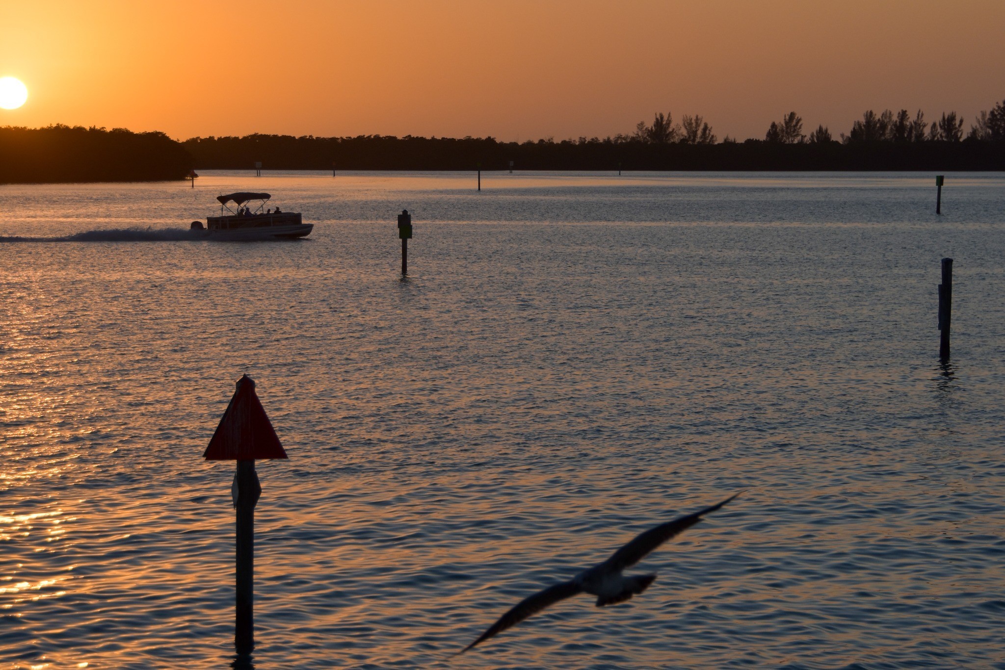 sunset on the stump pass inlet boat passing