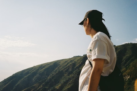 Man wearing cap standing on mountain landscape