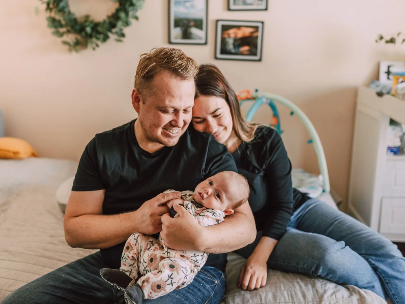 Maya and Chris holding their newborn at home