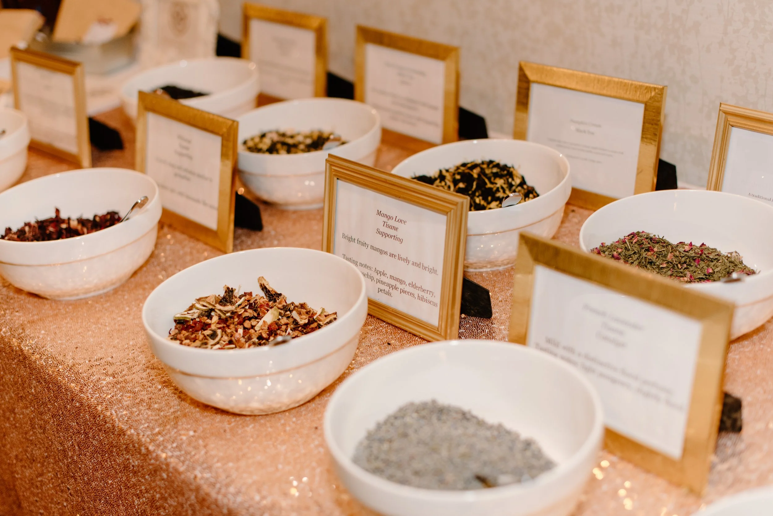 Gourmet loose leaf tea blending station with botanicals and glass jars for wedding favors