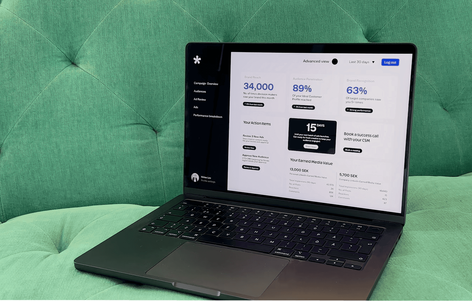 Sid Marketings dashboard on laptop in a green couch