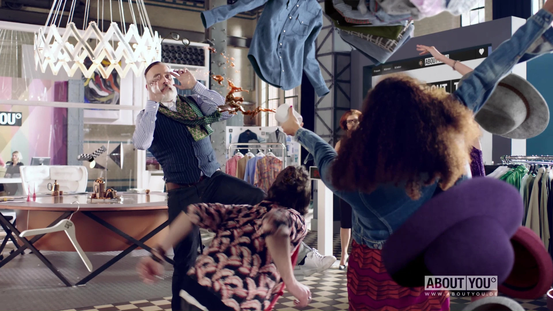A man ducking around other people and clothing items frozen in time.