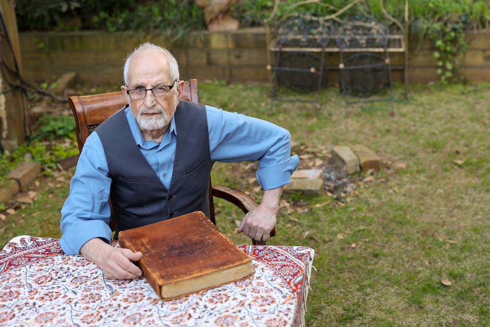 Bubjan with book and speaking to camera