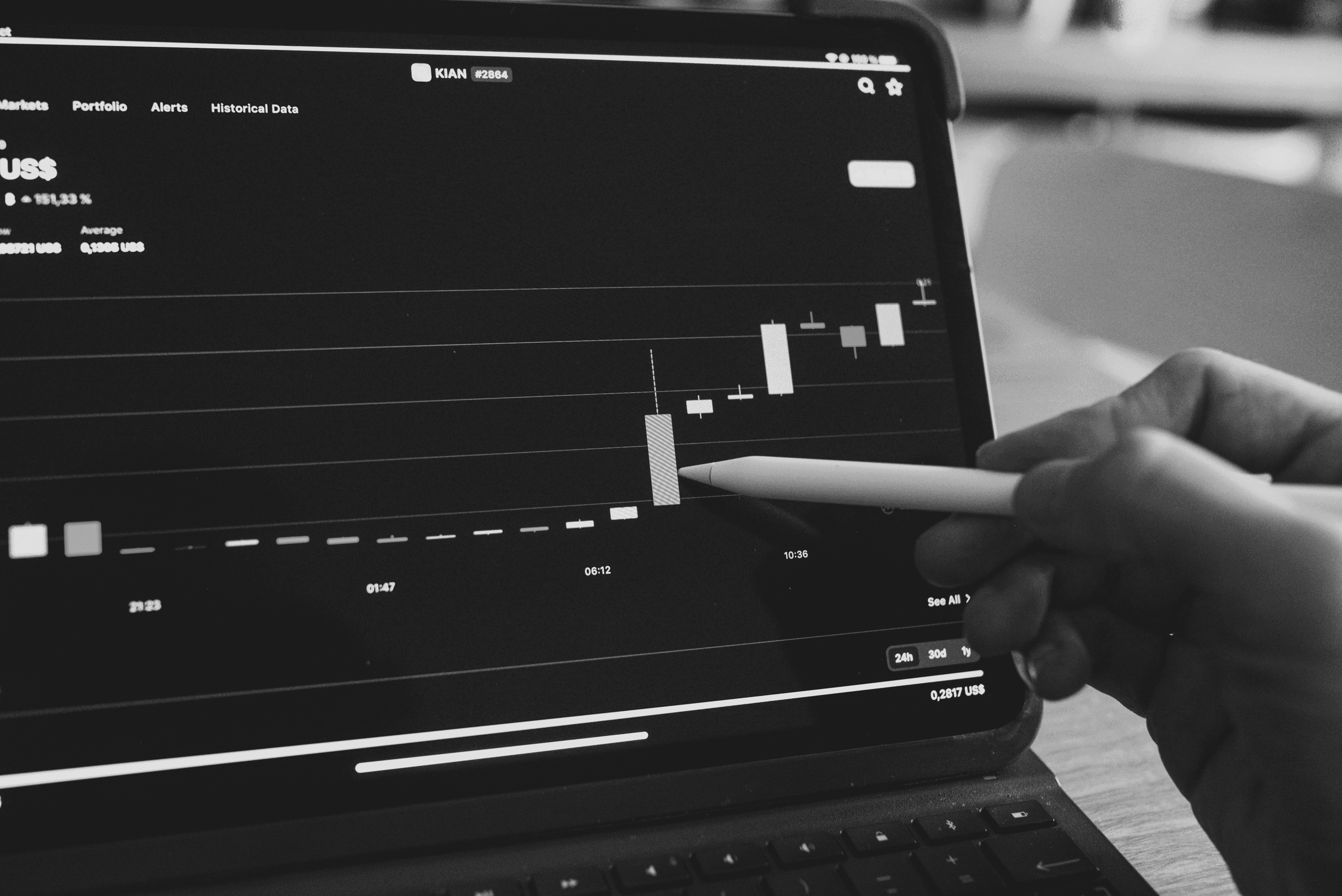 a person is holding a pencil in front of a laptop