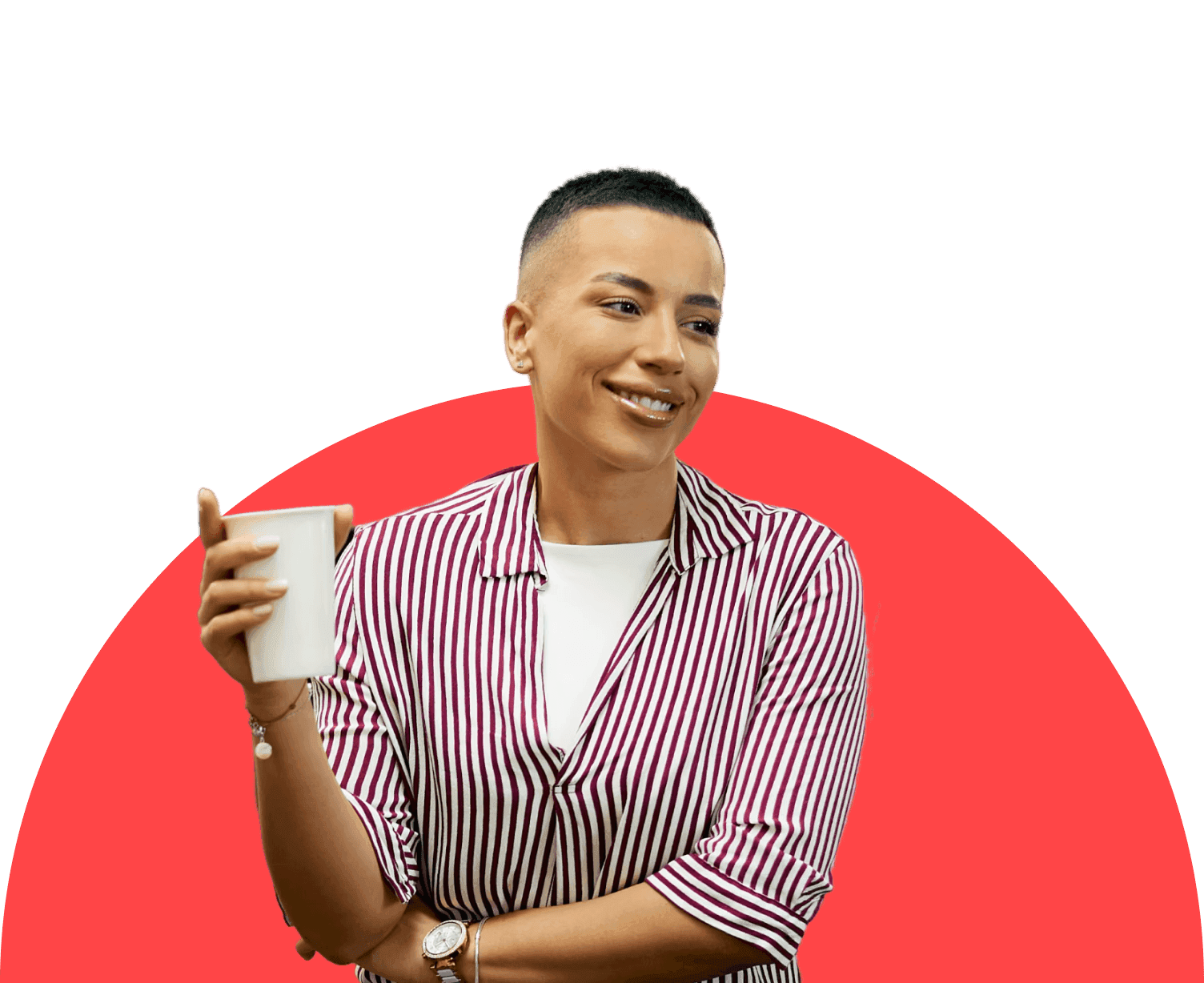 Woman with short hair wearing a red and white striped shirt smiles while holding a mug, standing against a minimal background