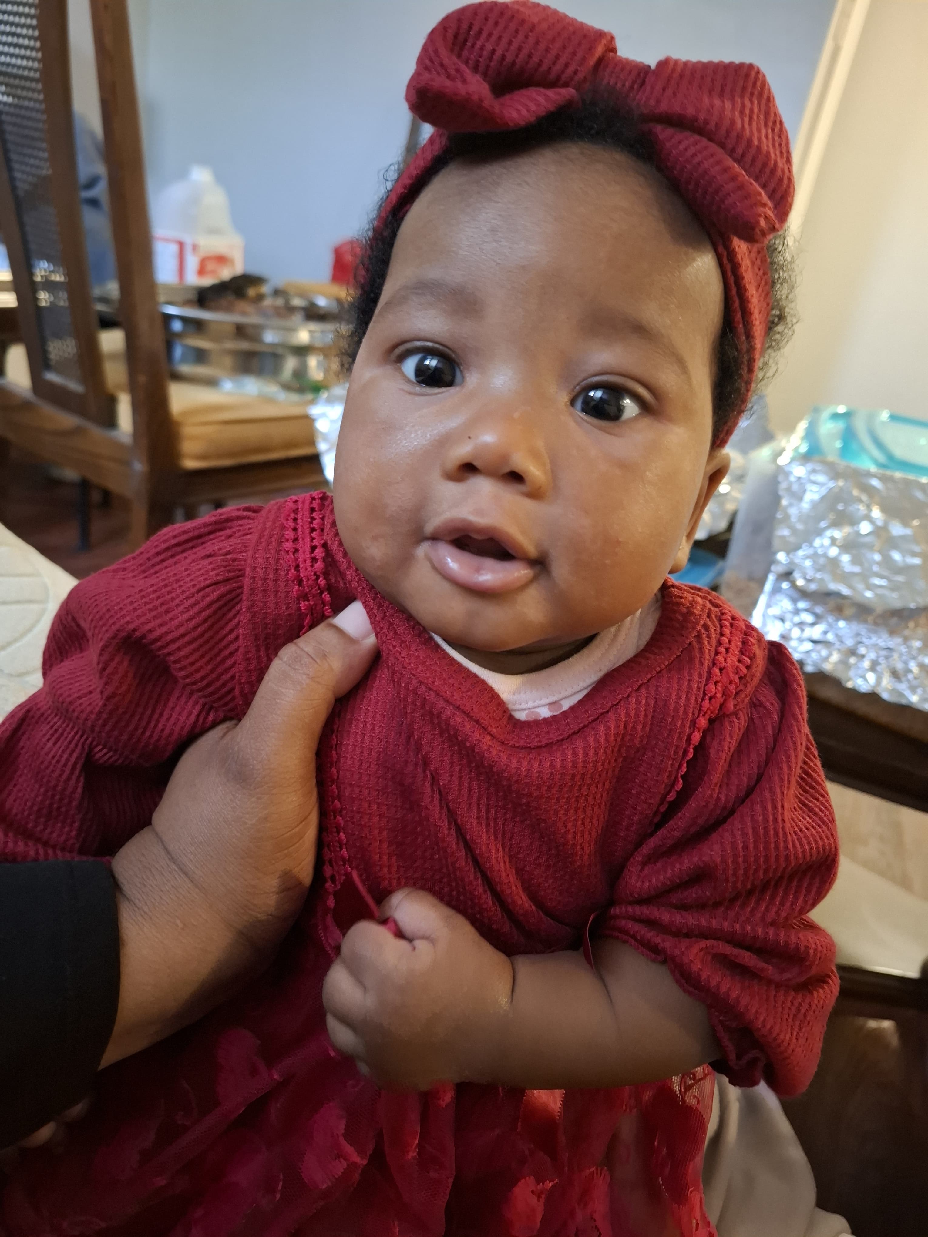 baby lying on pink textile