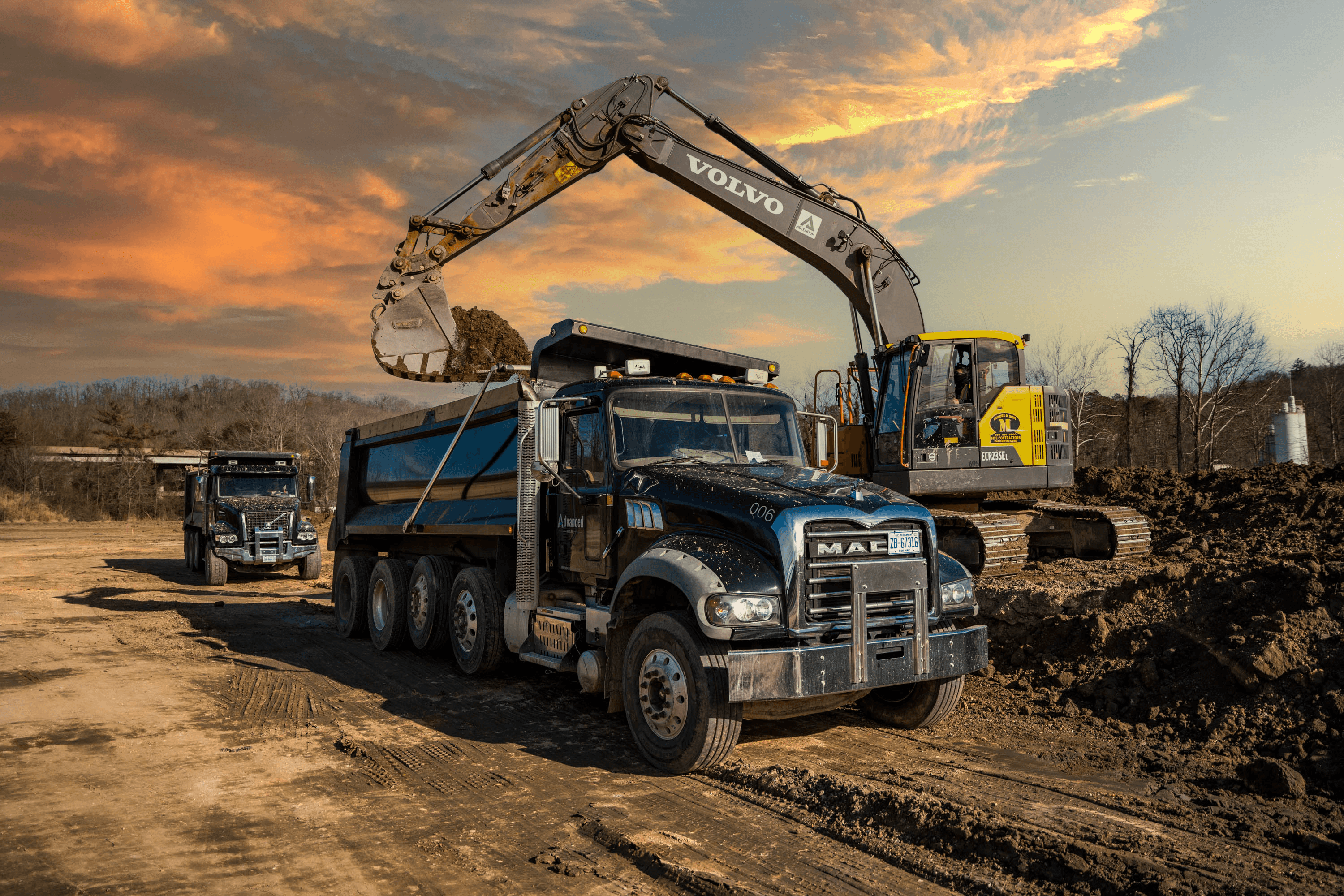MULTIPLE DUMP TRUCKS IN LINE WAITING TO GET LOADED BY EXCAVATOR