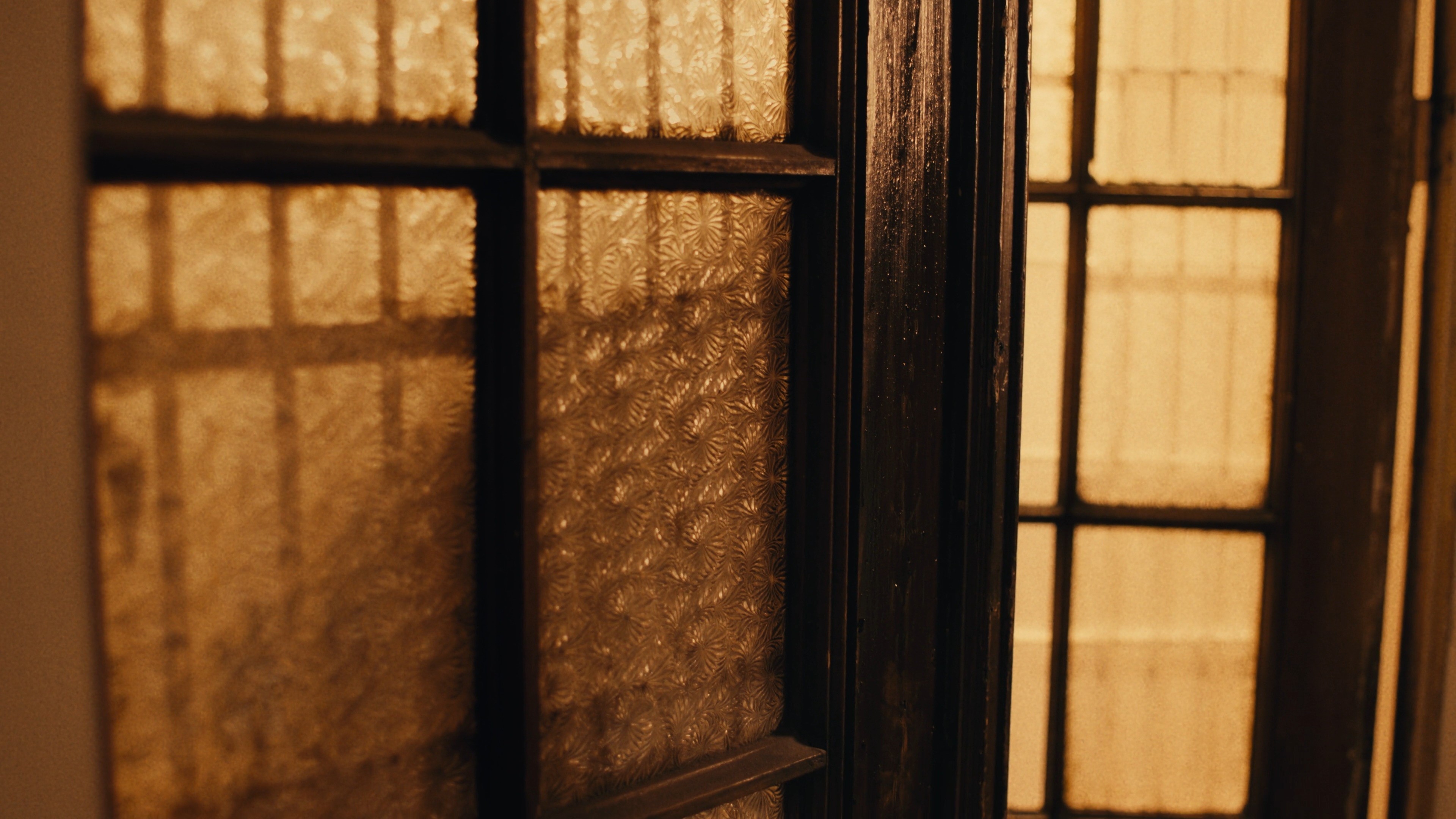 Sunlight streaming through a window grid, creating dramatic shadows.