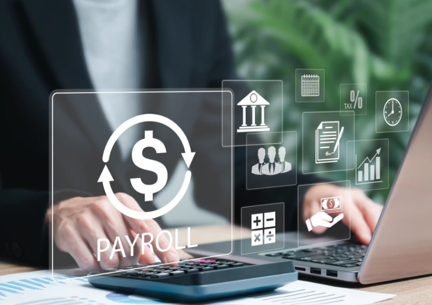 A man using calculator and an online platform for payroll representing automation and digitisation of processes.