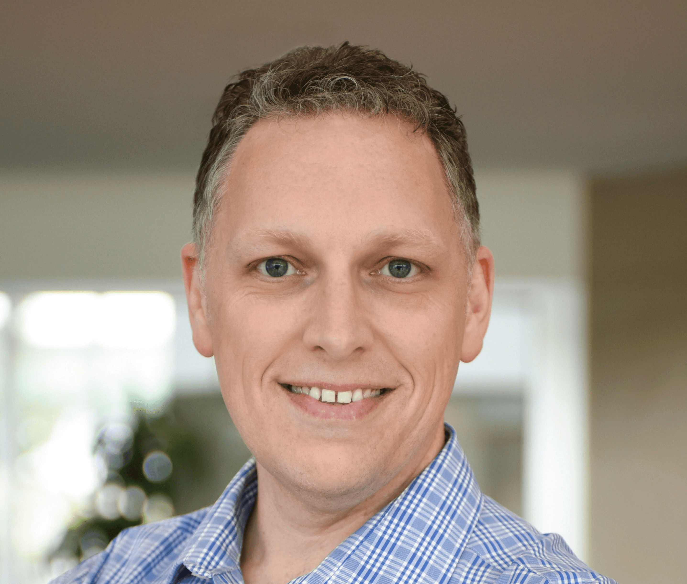 a man in a blue shirt smiling at the camera