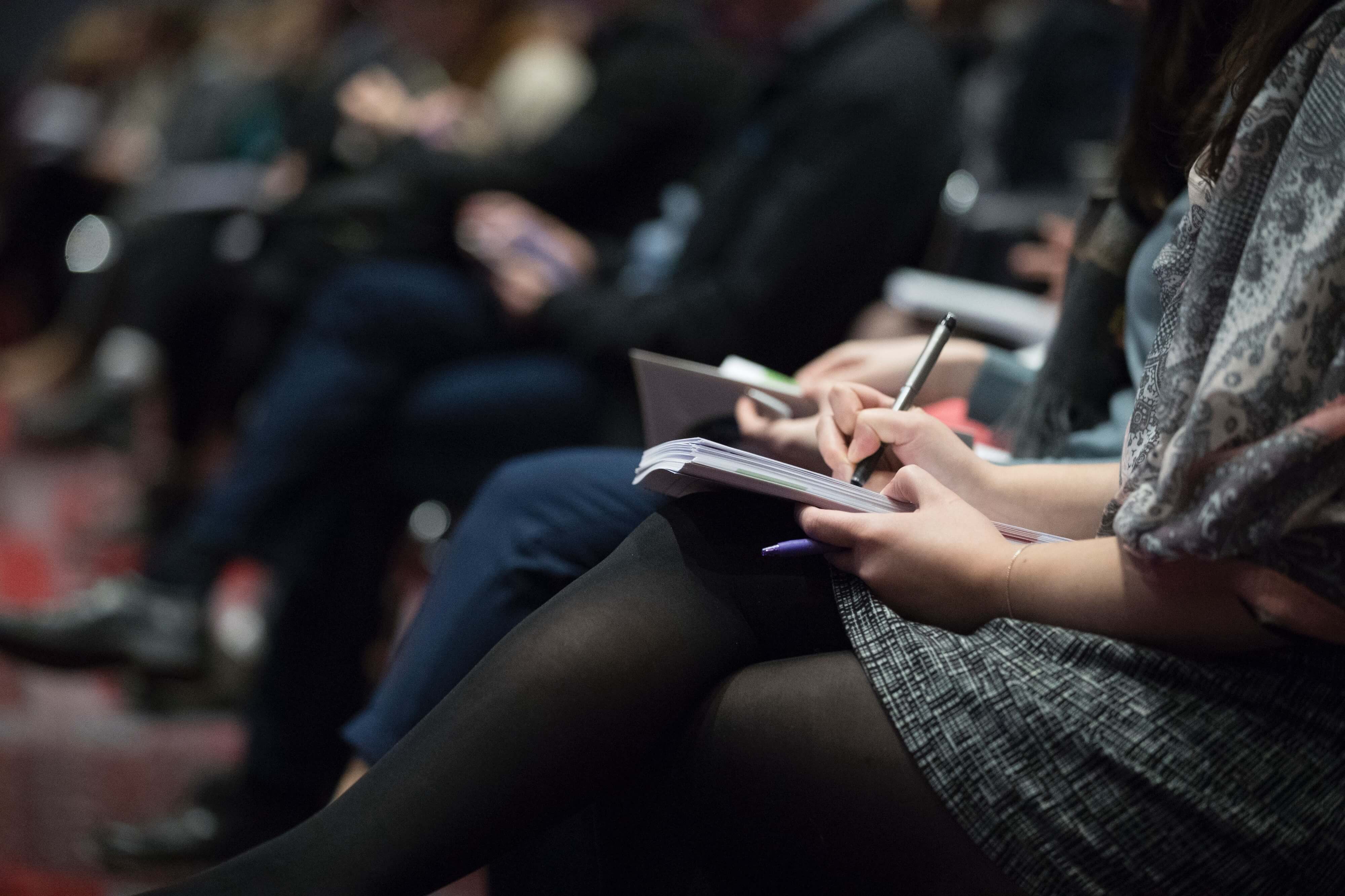 Woman Taking Notes at Conference