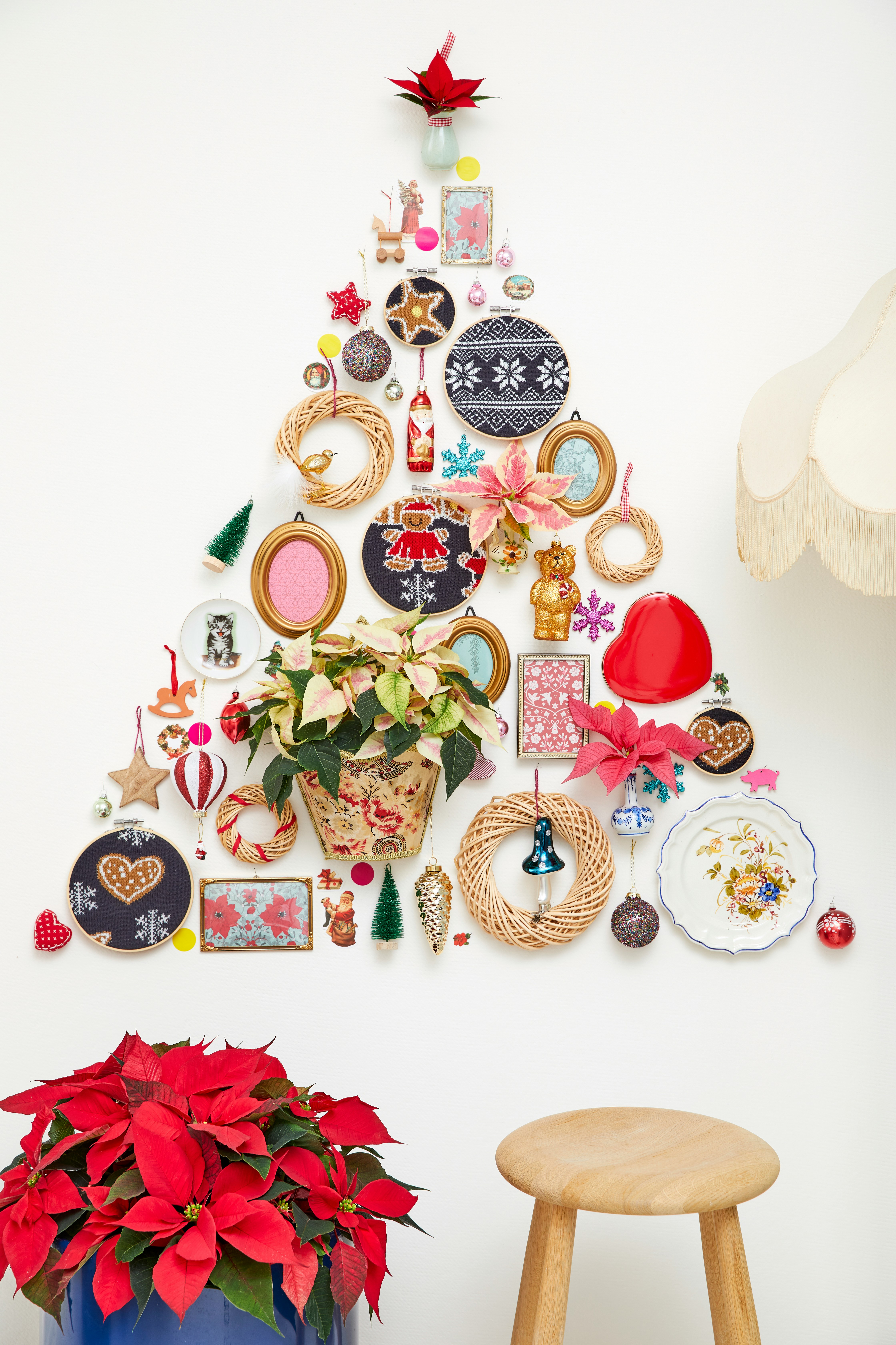 Christmas tree made of ornaments and decorations on wall.