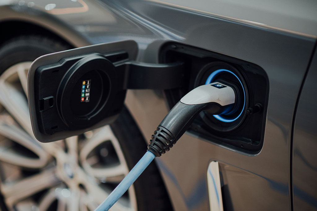 Close-up of an electric car being charged, with the charging cable connected to the vehicle's port.