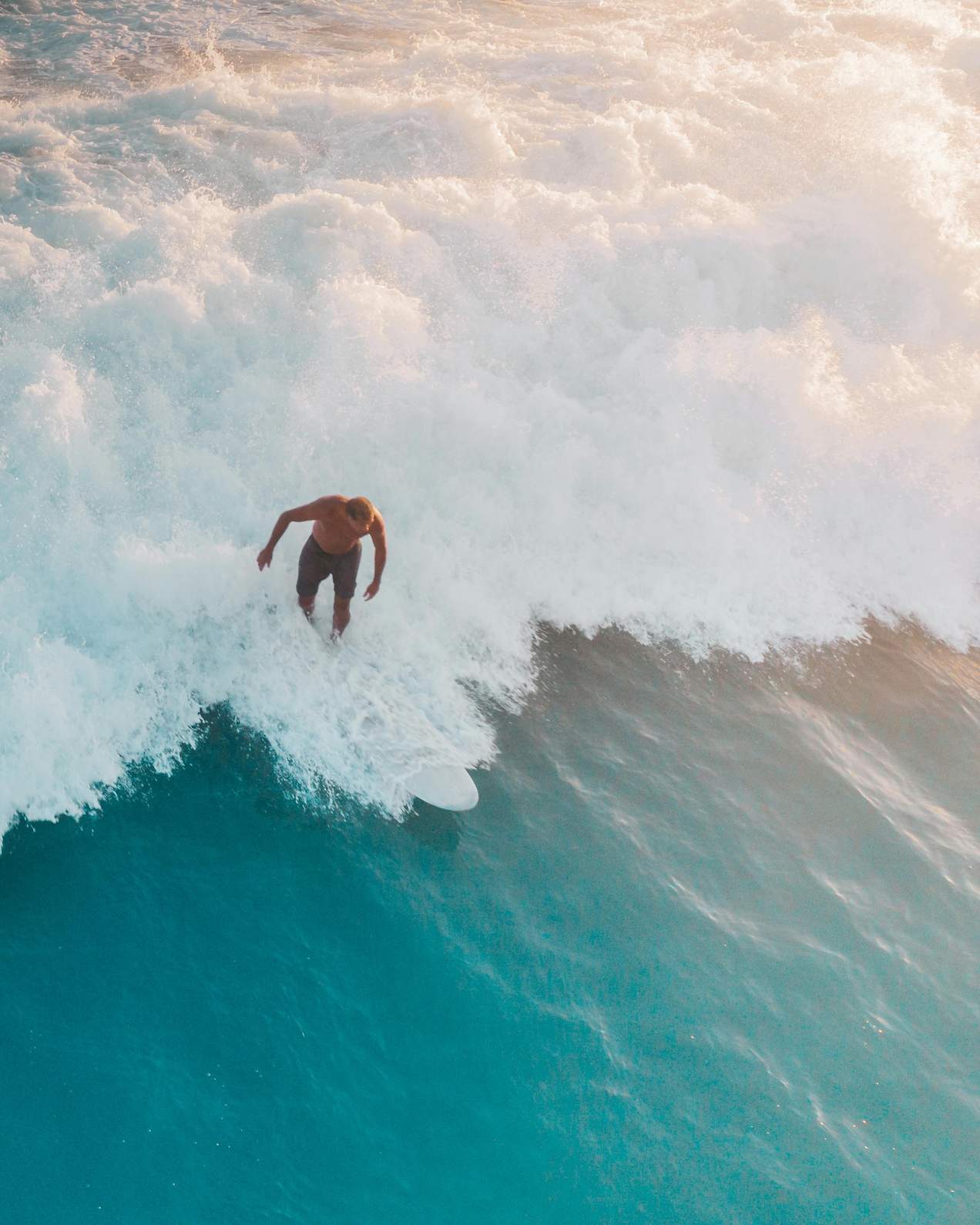 Shirtless man surfing on a wave – essential-surf-gear-every-surfer-should-have