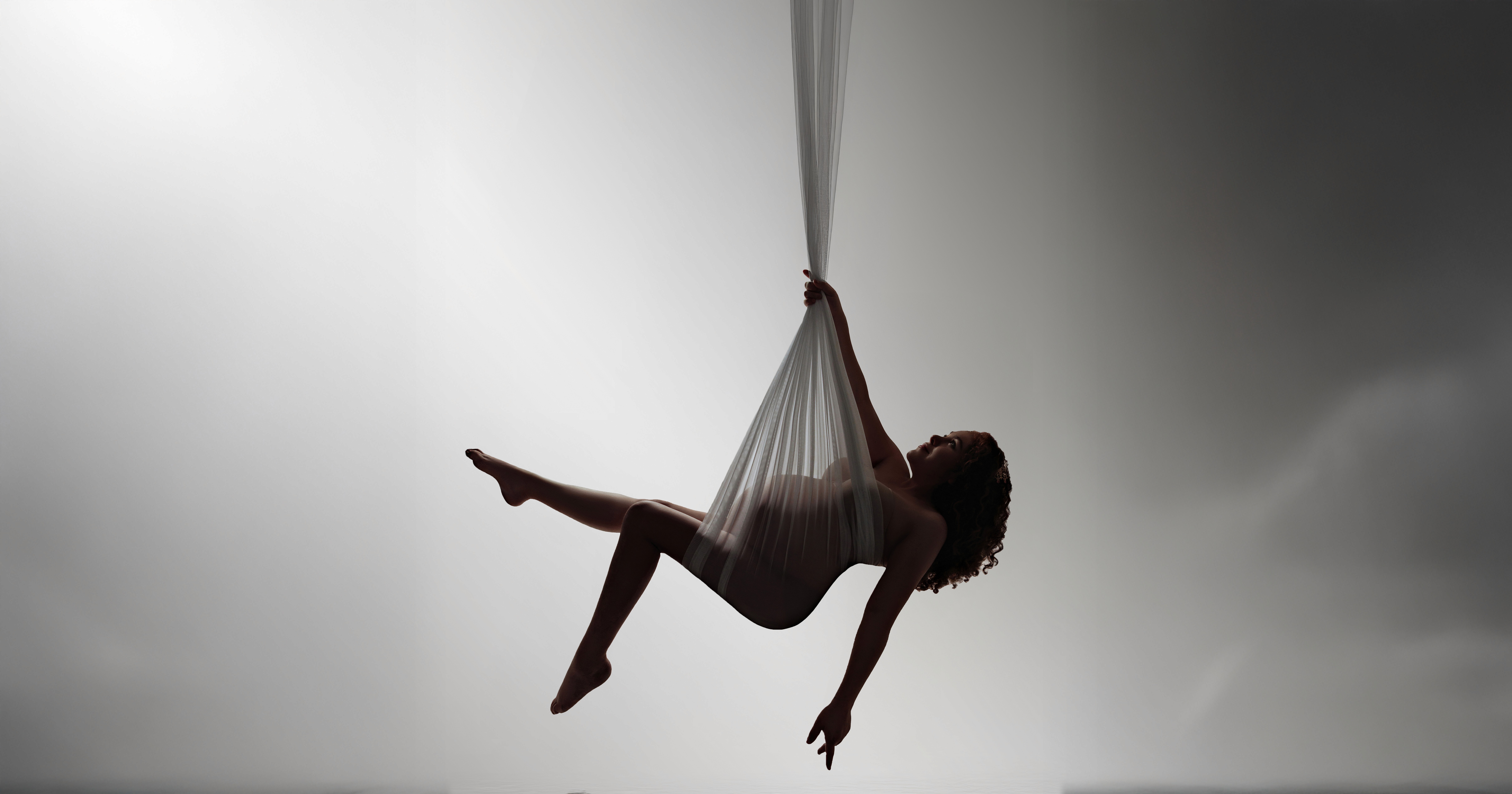 Elegant maternity photoshoot in Bloom N’ Baby Studio, Orange County — flowing gown and soft studio light.