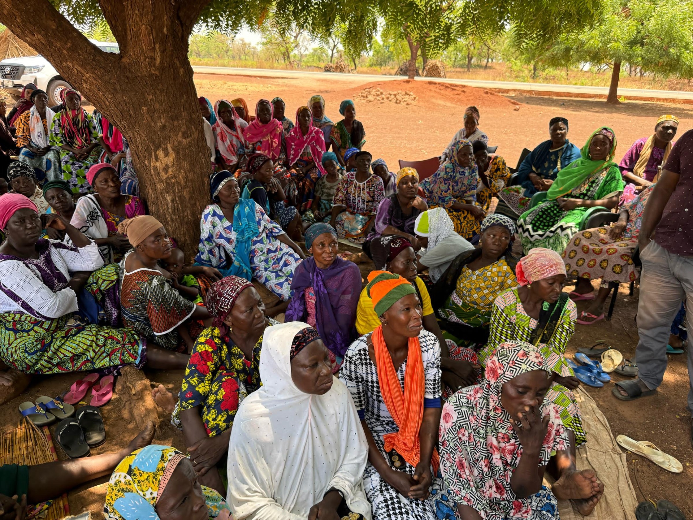 African Community sitting under tree learnign about new school provided by magic foundation