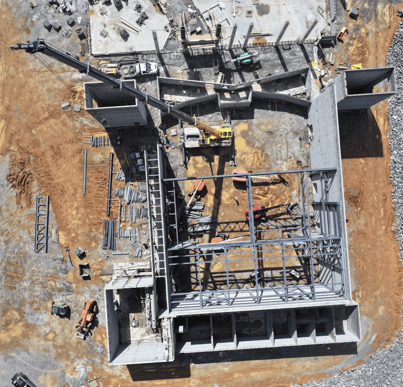 Aerial view of a construction site featuring unfinished structures and machinery on a brown landscape.
