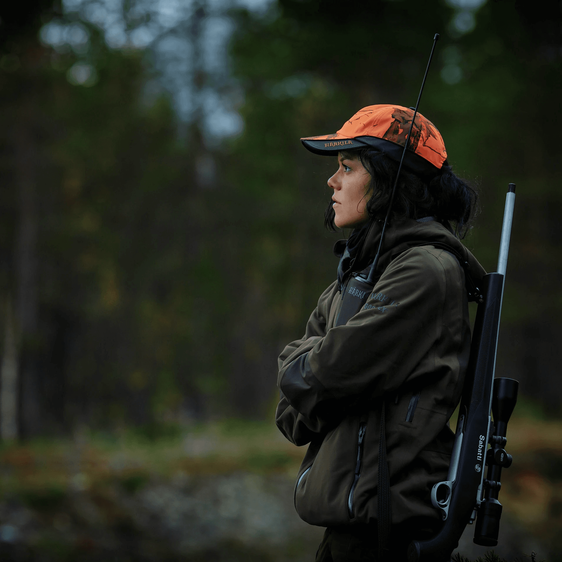 woman with orange hat and hunting rifle