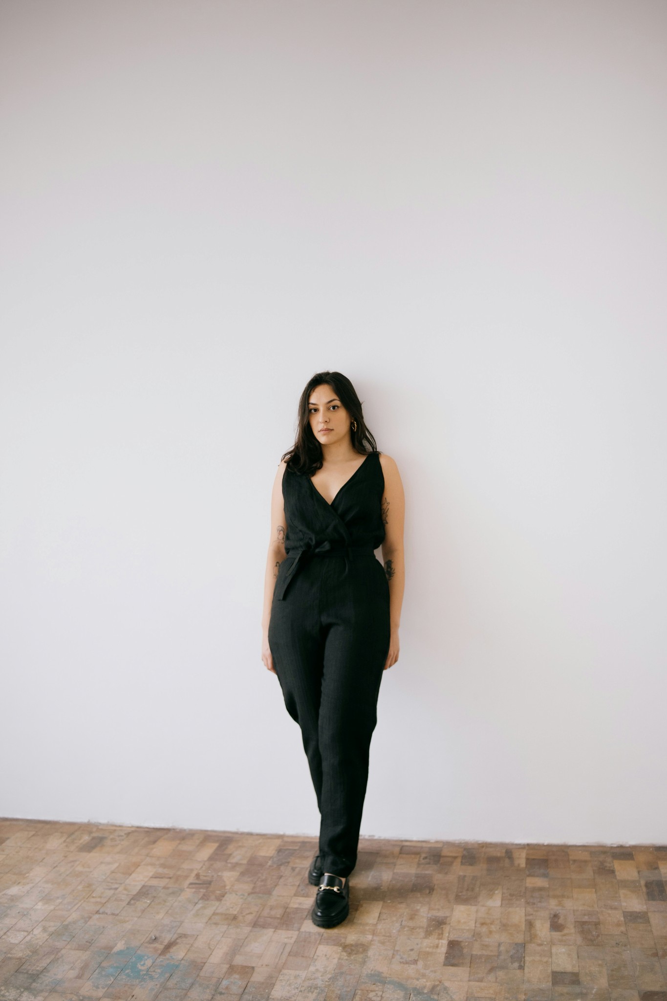 a woman standing in front of a white wall
