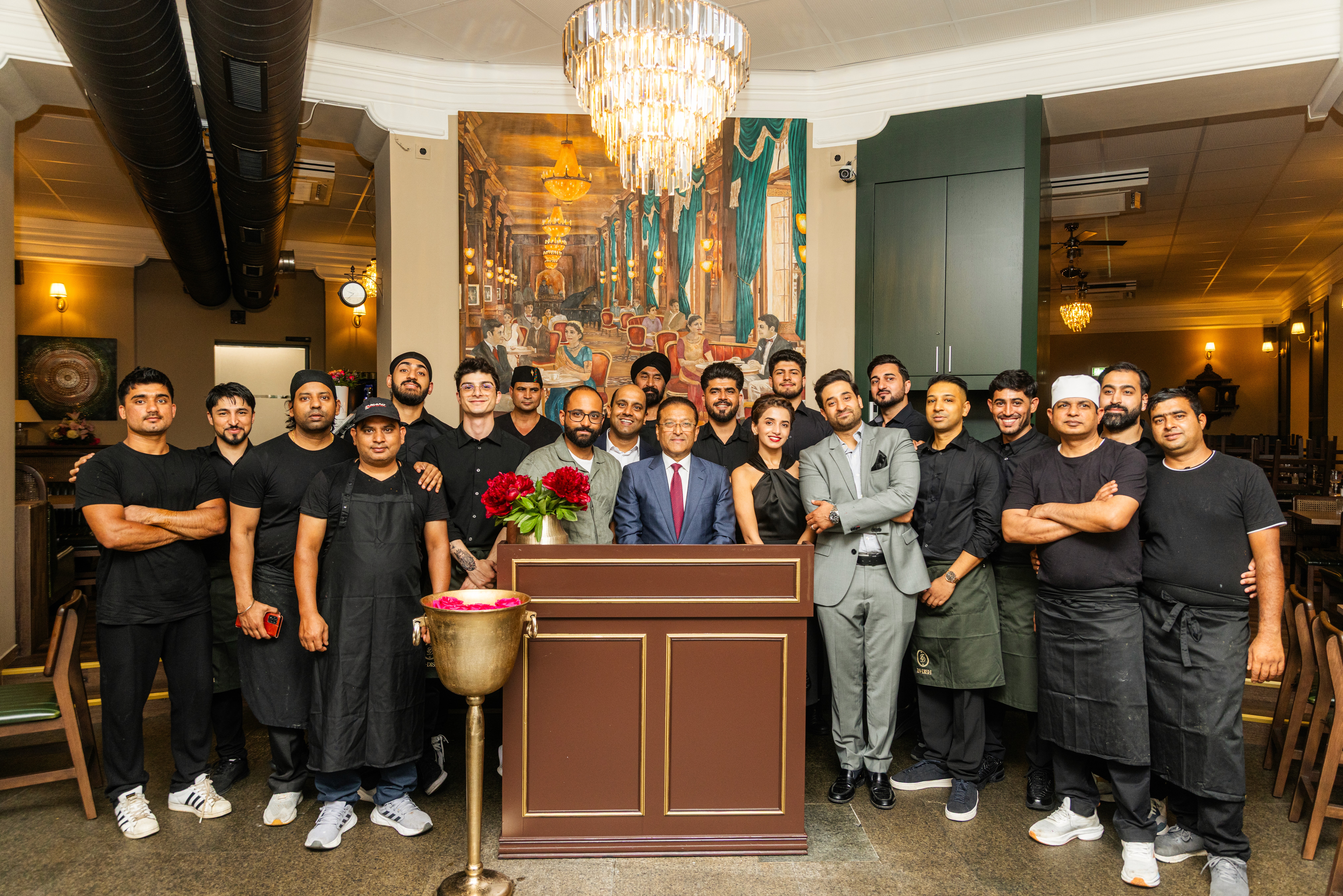 Restaurantinhaber mit Familie und Mitarbeiter vor dem In-Dish – indisches Fusion-Restaurant in Wien