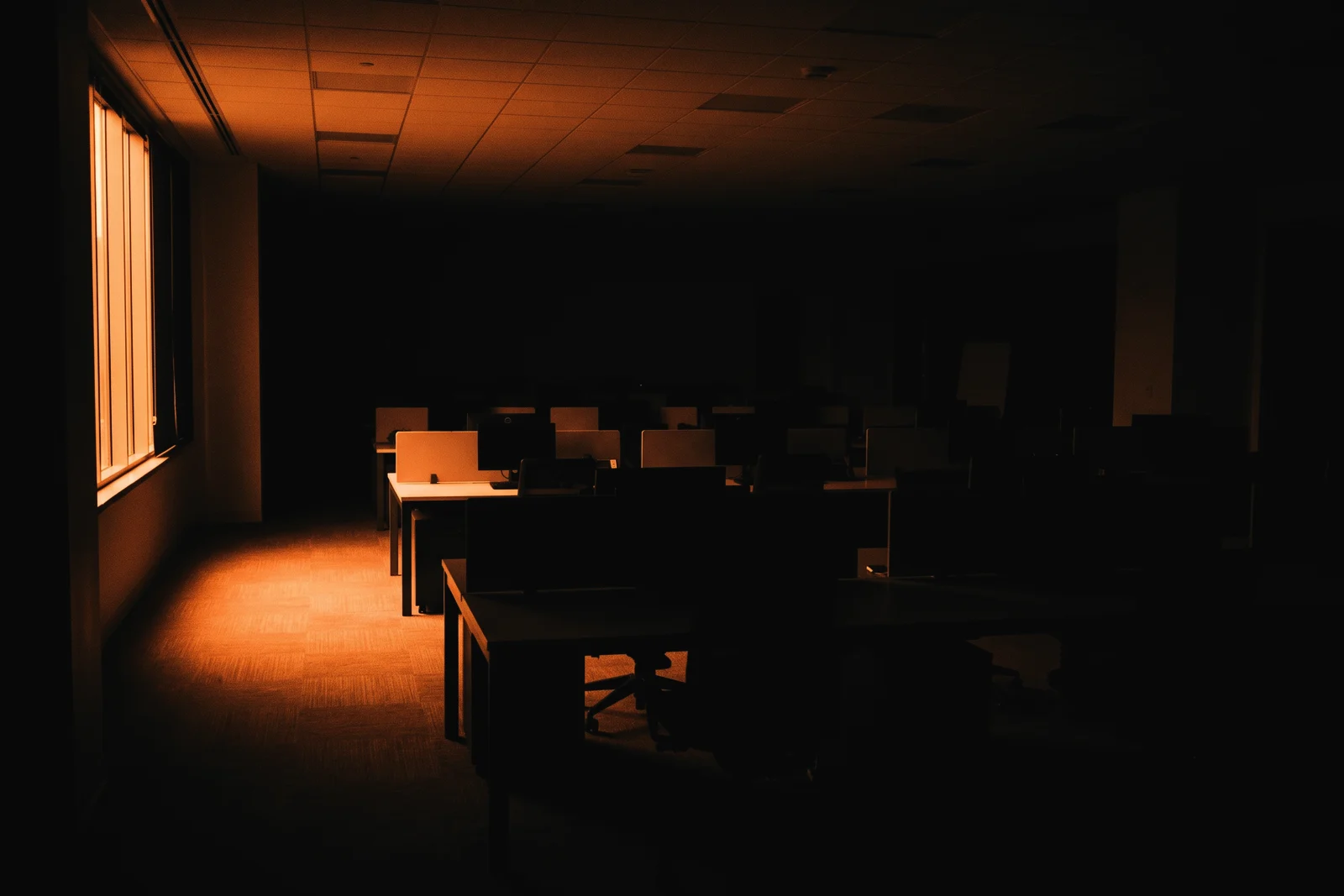 An empty open-plan office lit by a window
