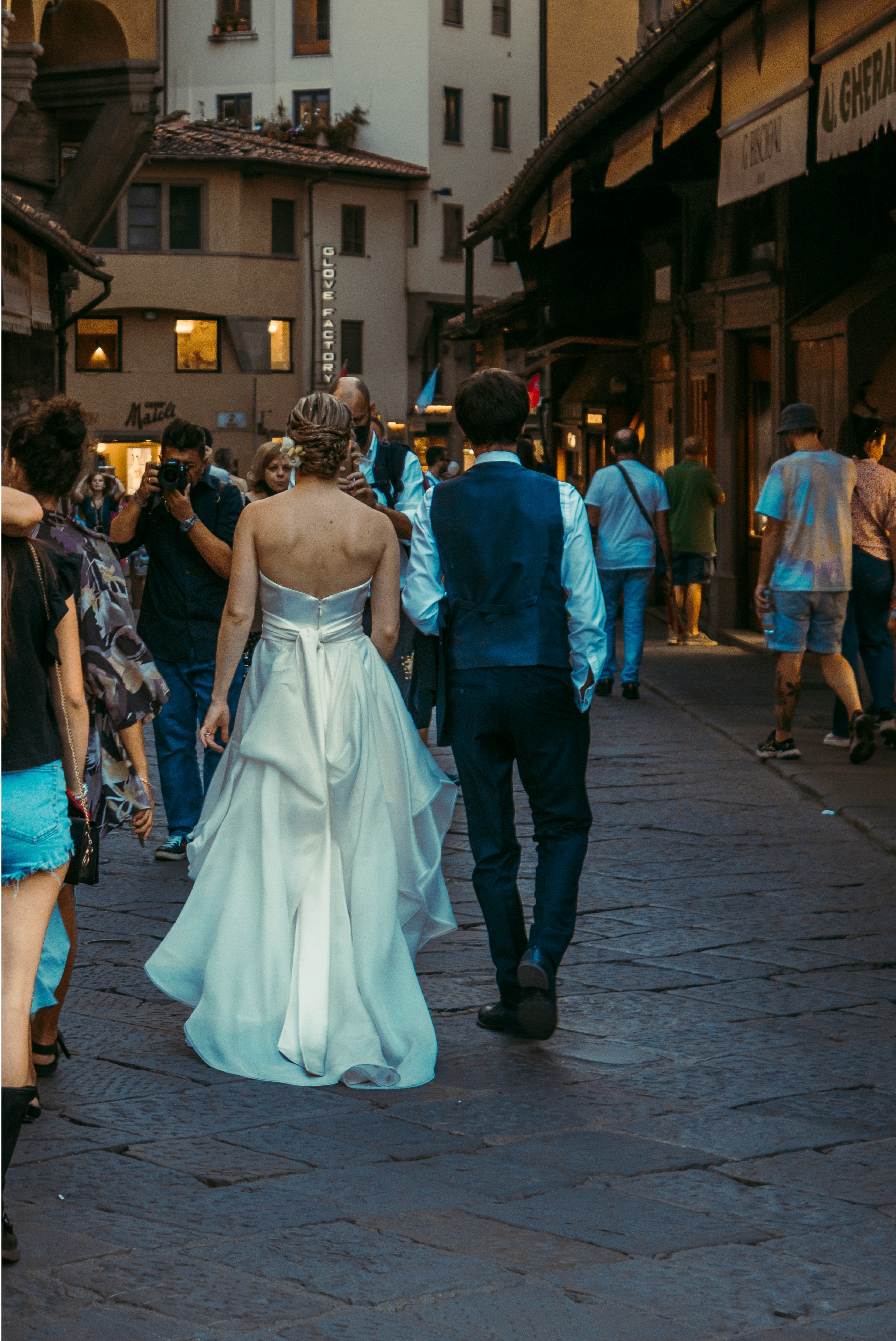 a bride and groom walking down the street
