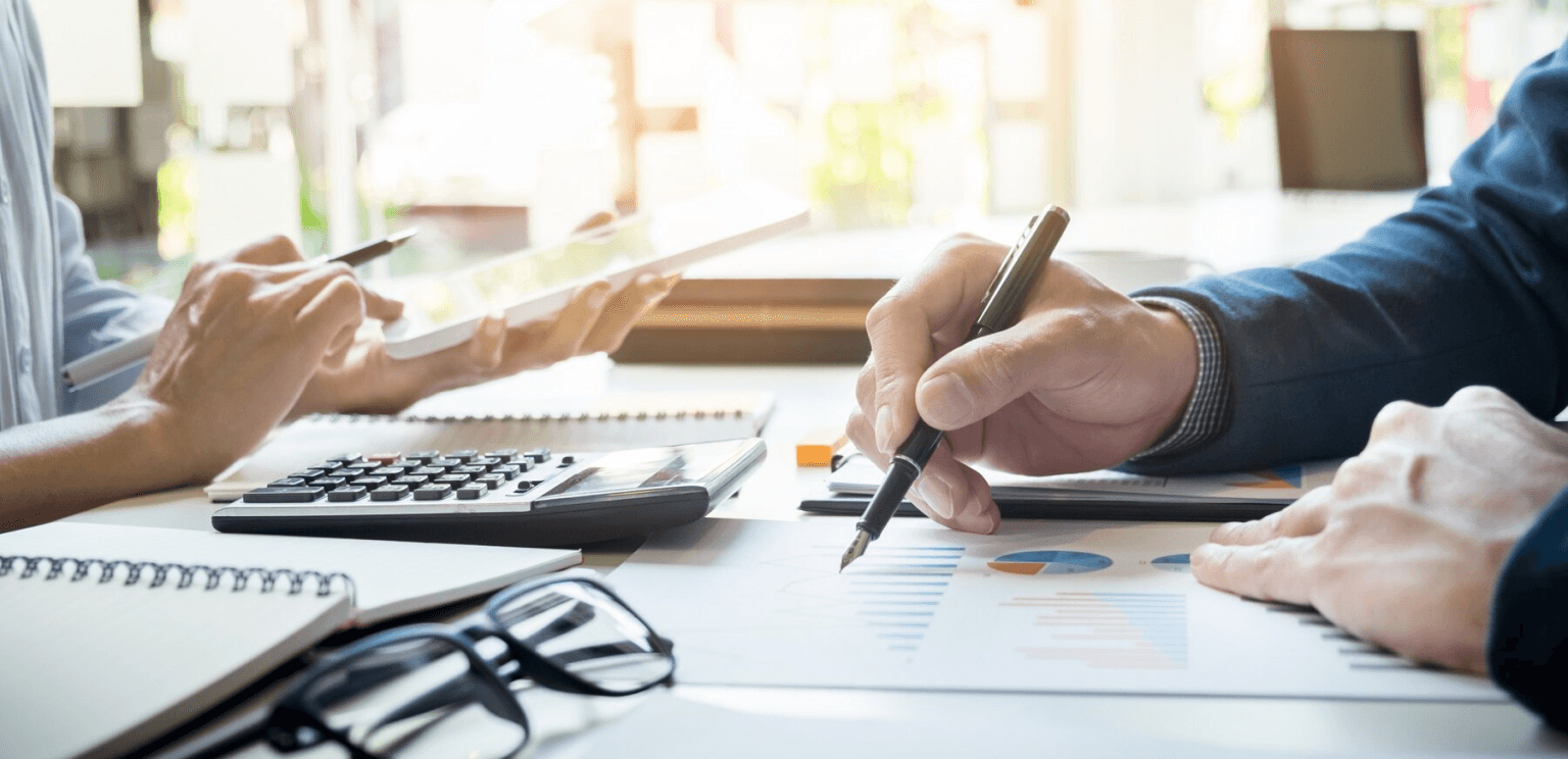 People working at desk, documents and calculator