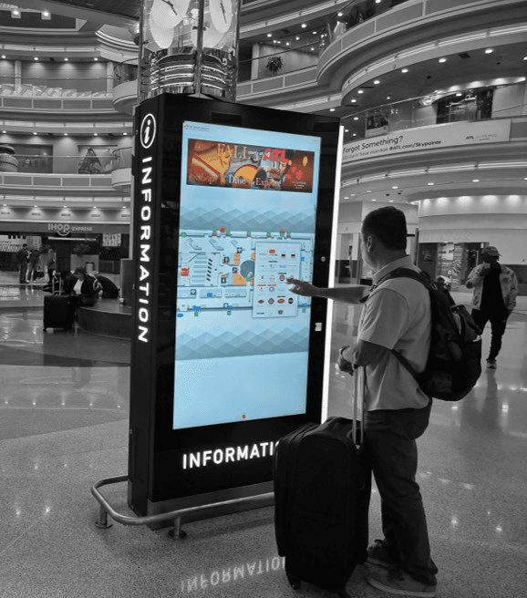 A photo of someone using an interactive wayfinding kiosk