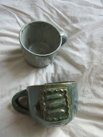 Teal ceramic mug with floral pattern and matching saucer