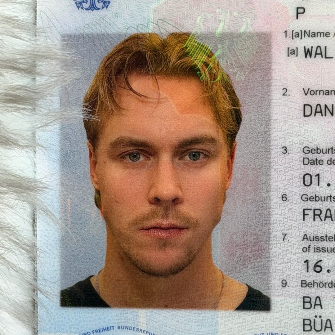 Smiling woman in a pink blazer and white shirt stands in a softly lit office with modern decor, conveying a professional and friendly tone.