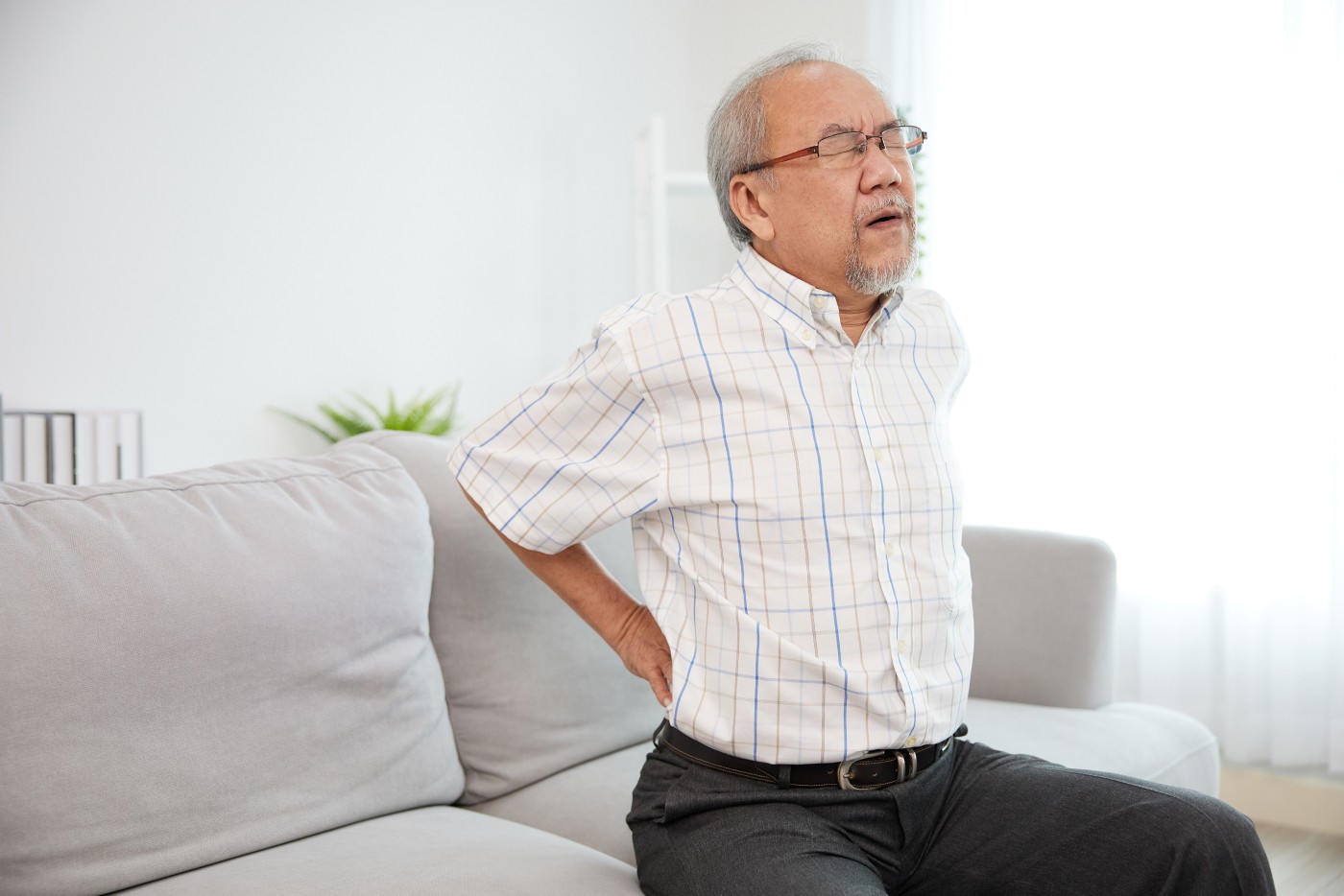 背中を押さえて辛そうな男性