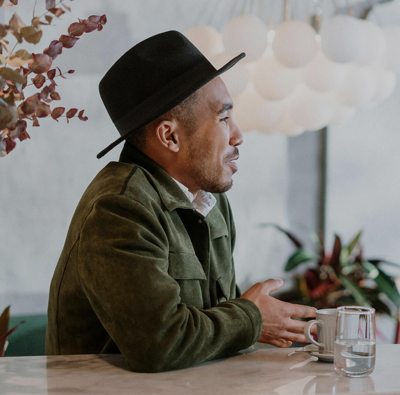 The side view of a younger man in a hat