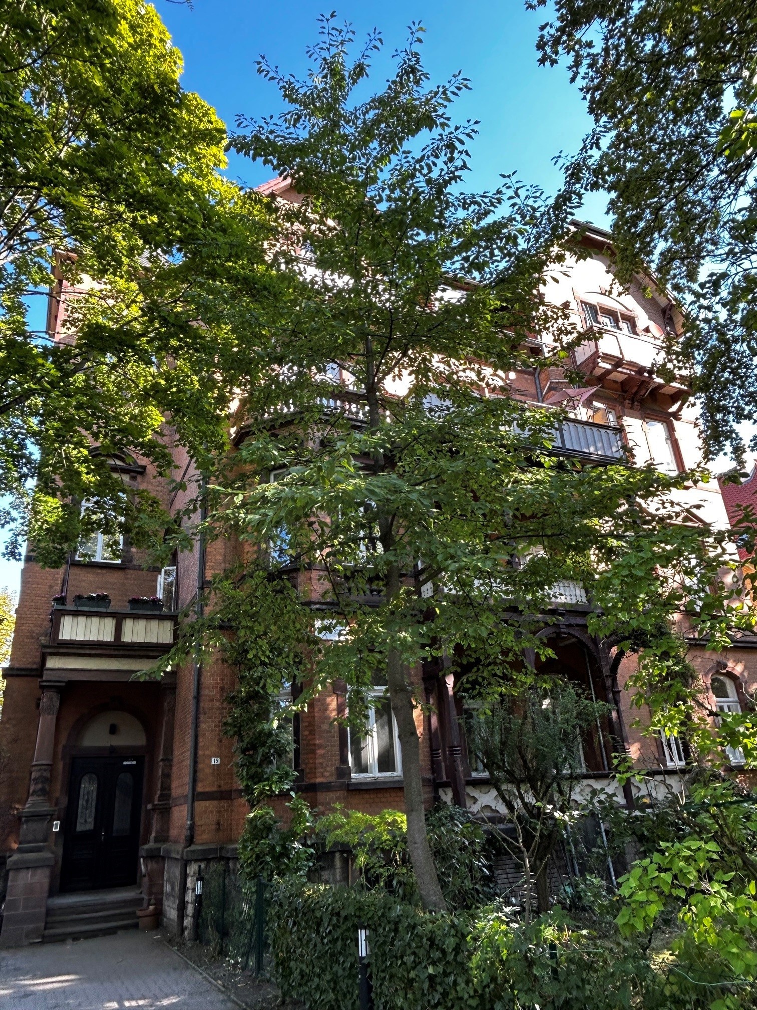 Von grünen Bäumen und Garten umgebenes Wohnhaus