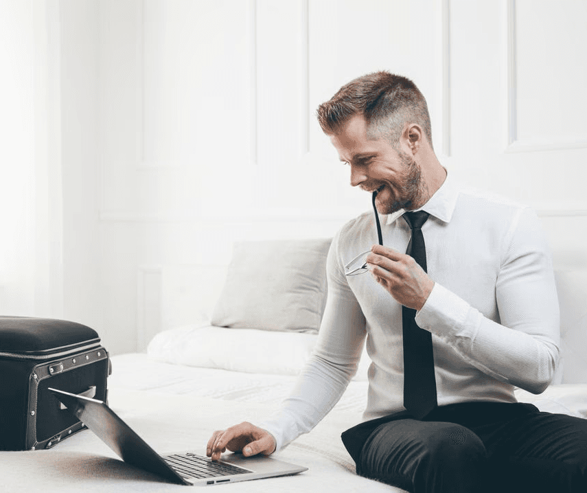 Person seated in a bed looking at laptop