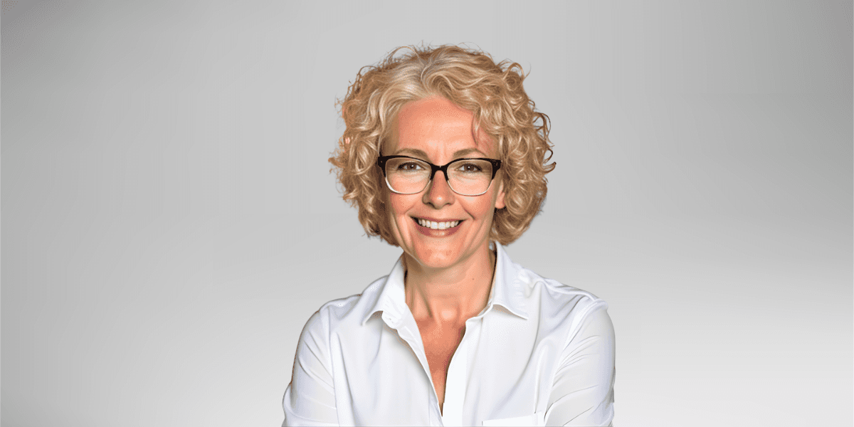 A woman named Nancy Parsons, wearing glasses and a white shirt, poses for the camera with a friendly expression.