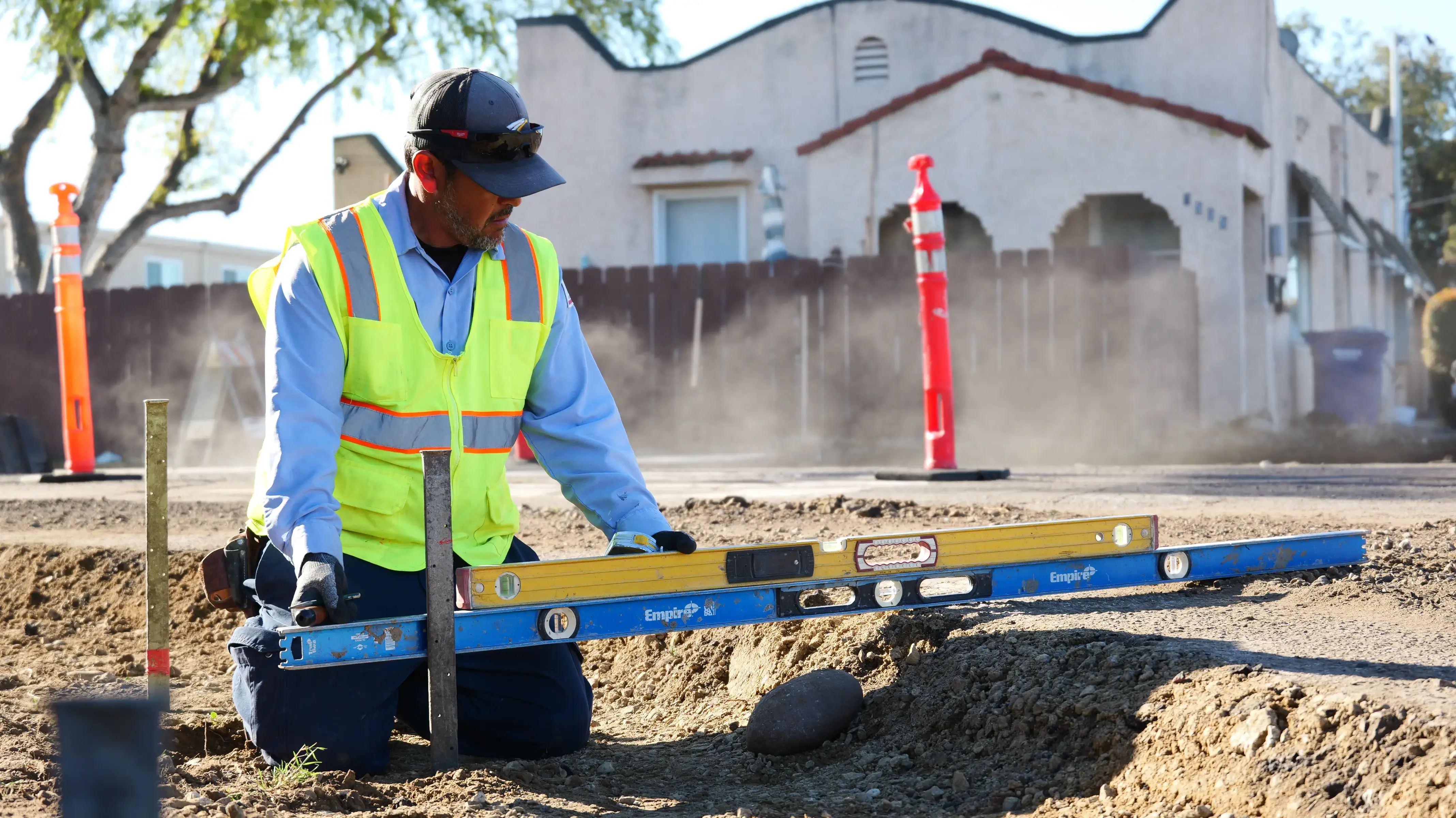 Asphalt crew using level to measure grade
