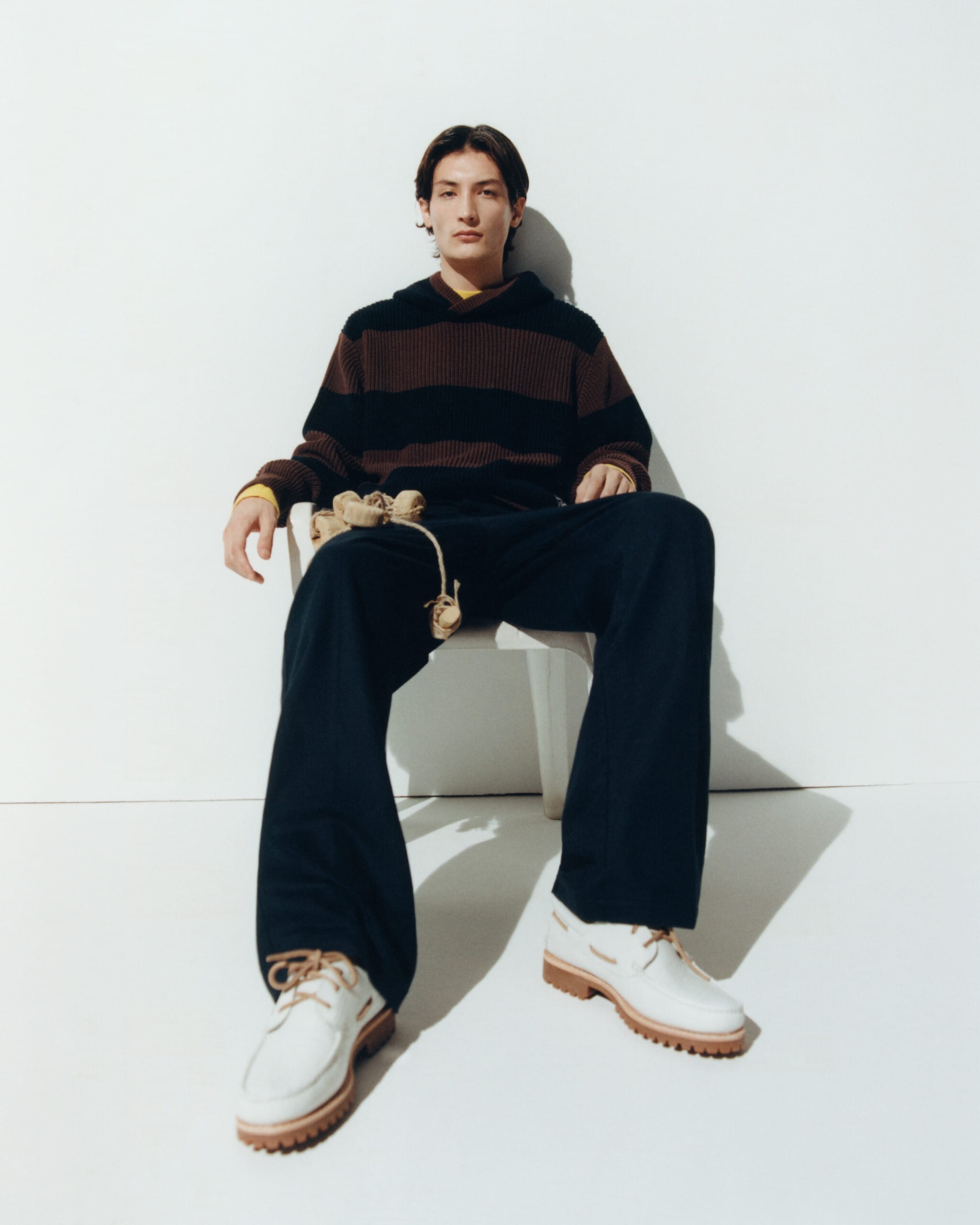 Ce mannequin du lookbook Thinking Mu porte un pull et un pantalon noir