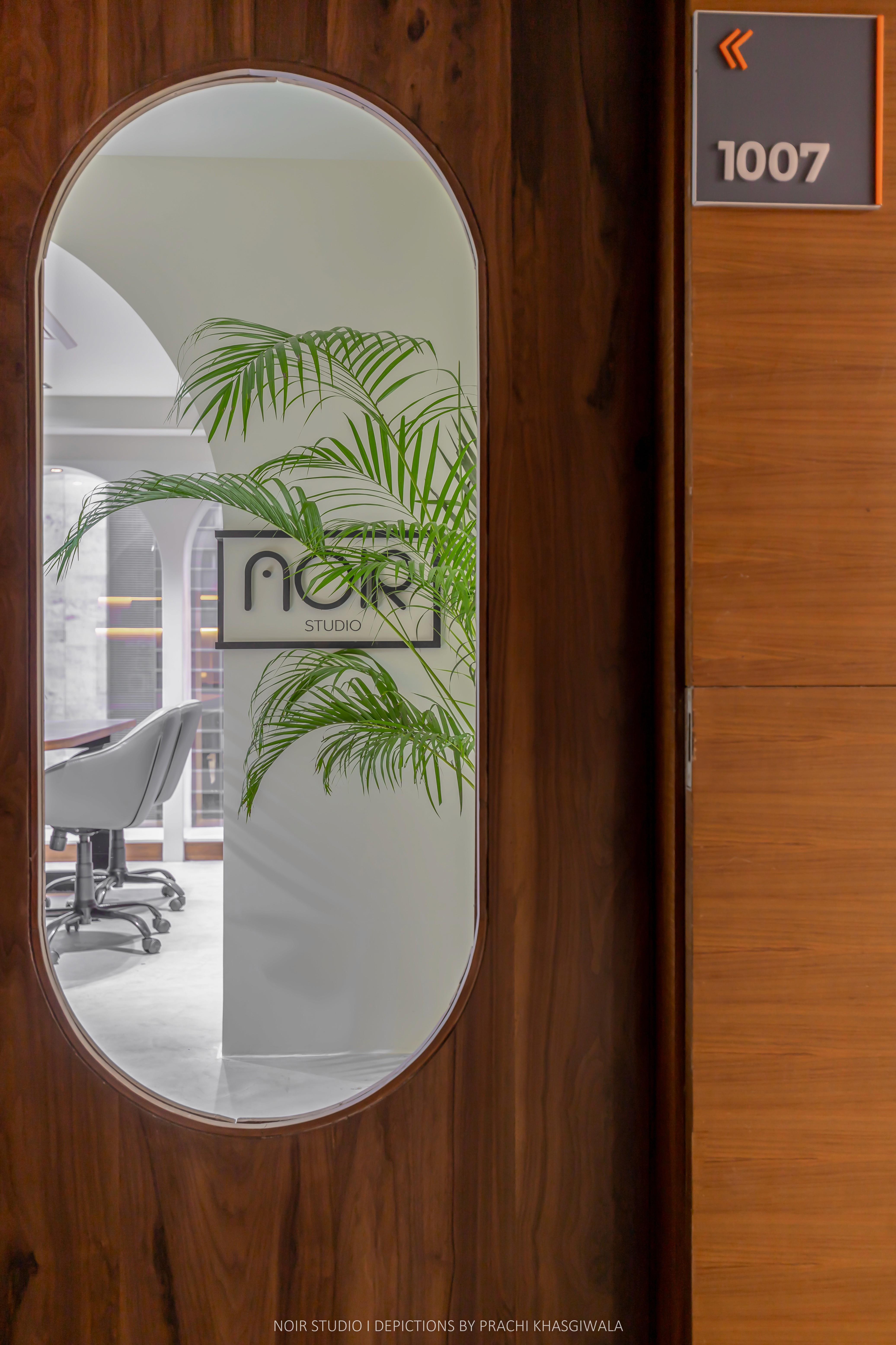 Black and white image of people working at a table with laptops, showing hands gesturing during discussion of digital content displayed on screens, with fabrica® logo in the corner.