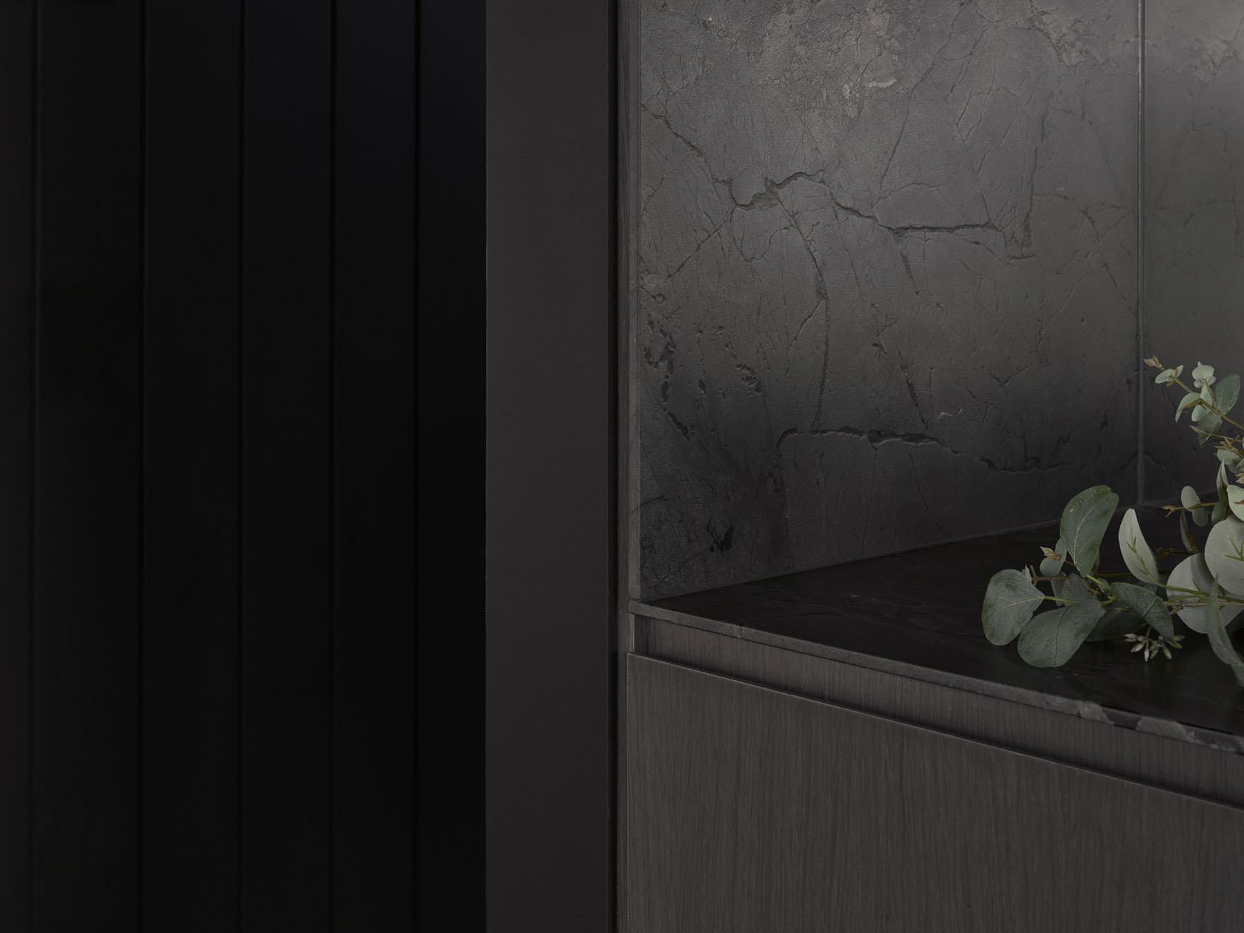 bar detail with dark timber cabinetry and textured stone surface
